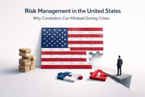 An illustrated cover image titled “Risk Management in the United States: Why Correlation Can Mislead During Crises.” The scene shows a large U.S. flag formed by interlocking puzzle pieces, with one piece missing, symbolizing hidden weaknesses in assumed correlations. In the foreground, detached puzzle pieces include a red piece with an exclamation mark, highlighting risk and warning signals. On the left, a stack of wooden blocks represents seemingly stable structures, while on the right, a lone businessman stands at the edge of a platform, observing the incomplete puzzle. The minimalist setting emphasizes uncertainty, fragility, and the challenges of relying on correlation during financial crises.